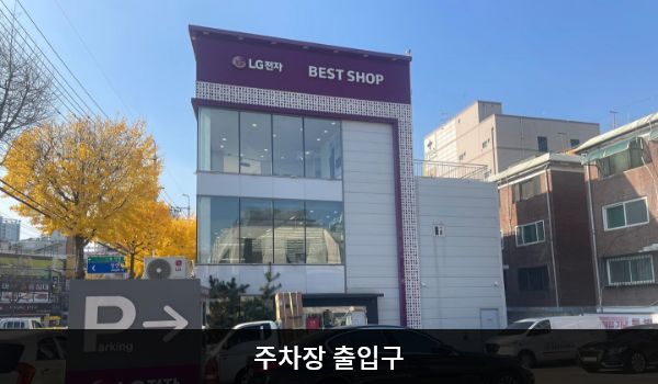 북수원서비스센터의 건물 뒤편에 지상 주차장이 있습니다. 건물 앞에 'Parking', 'LG전자 고객주차장'이라고 쓰인 곳입니다. 주차장을 통해 들어갈 수 있는 자동문 출입구도 있으며, 문 앞에 점자블록이 있습니다.