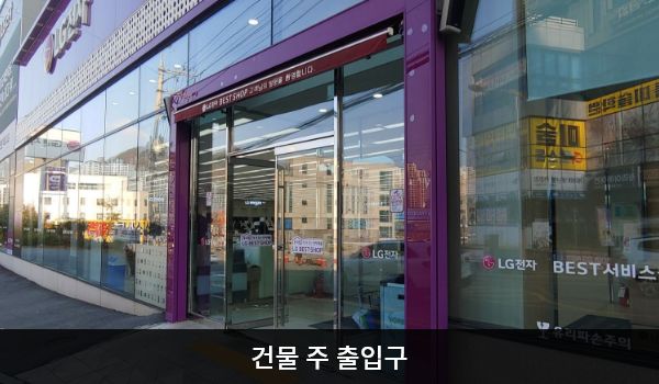 거제서비스센터의 대로 앞, 건물 중앙에 여닫이문 출입구가 있고, 문 앞에 점자블록이 있습니다. 여닫이문을 열고 들어간 후에 문이 한 번 더 있습니다.