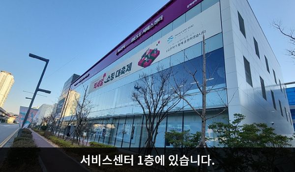 김해서비스센터의 서비스센터 건물은 가로로 길고 유리창이 많습니다. 건물 위쪽 간판에 'LG전자 BEST SHOP 베스트샵', 'LG전자 BEST 서비스센터'라고 쓰여 있습니다.