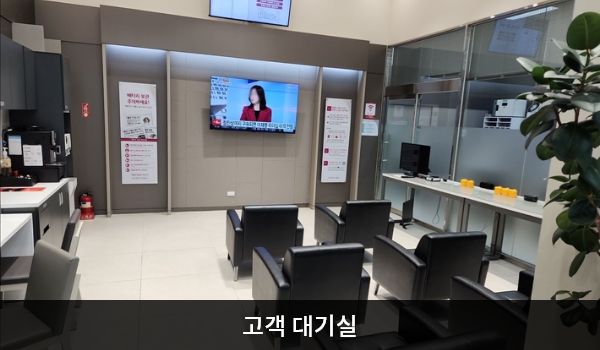 김해서비스센터의 현관문으로 들어오시면 상담 창구와 고객 대기실이 있습니다. 앉아서 대기하실 수 있는 의자가 마련되어 있습니다. 정수기와 커피, 대기 중 이용하실 수 있는 PC도 준비되어 있습니다.