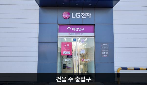 해남서비스센터의 건물을 바라보았을 때 중앙에 여닫이문 출입구가 있으며, 문 앞에 점자블록이 있습니다. 건물 뒤편 주차장을 통해 들어갈 수 있는 출입구도 있습니다. 뒤편 출입구는 문 위에 '매장 입구'라고 쓰여 있고, 여닫이문입니다.