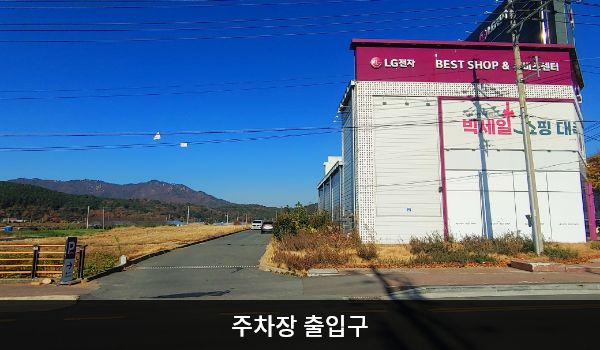 해남서비스센터의 건물 왼쪽으로 꺾어 뒤편에 지상 주차장이 있습니다. 주차장 출입구 근처에 'Parking LG전자 고객주차장'이라는 안내판이 세워져 있습니다.