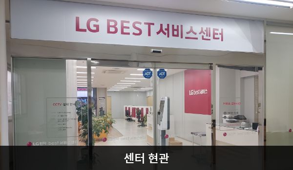 제천서비스센터의 센터 현관 위쪽에 'LG BEST 서비스센터'라는 문구가 적혀 있으며, 그 아래에 유리로 된 자동문이 있습니다. 오른쪽 문에 문 열림 버튼이 있습니다.