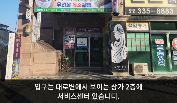 영천서비스센터의 대로 앞 건물 왼쪽 끝에 상가 출입구가 있습니다. 건물 벽과 벽 사이가 움푹 들어간 부분 안쪽으로 직진하시면 여닫이문 출입구가 있습니다. 문 위에 'LG BEST 서비스센터 2F 영천 서비스센터'라고 쓰여 있습니다.