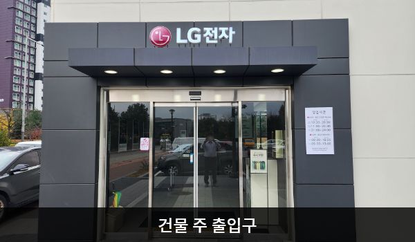 서인천서비스센터의 건물 주 출입구 위에는 검은 바탕에 'LG전자' 문구가 적혀 있습니다. 자동문으로 되어 있으며, 왼쪽 문 안쪽에 문 열림 버튼이 있습니다.