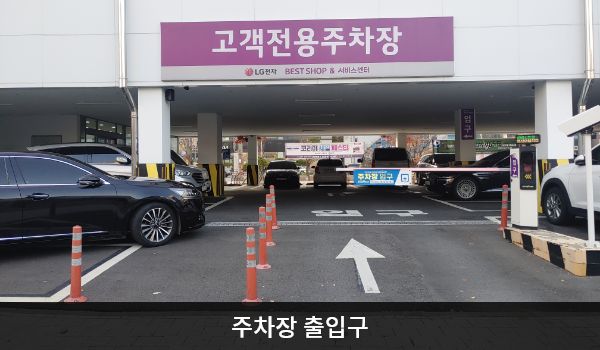군산서비스센터의 건물 뒤쪽에 주차장 출입구가 있습니다. 주차장 출입구 위에 '고객전용주차장'이라고 크게 쓰여 있습니다.