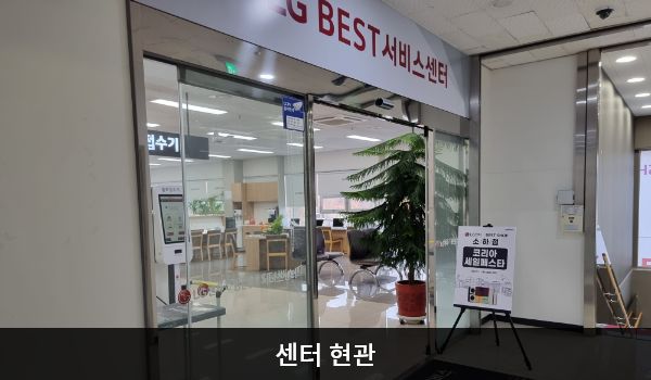 광명서비스센터의 3층 현관문 위쪽 큰 흰색 간판에 'LG BEST 서비스센터'라고 적혀 있습니다. 현관문은 자동문이고, 문 왼쪽에 열림 버튼이 있습니다. 들어오시면 앞에 셀프 접수기와 접수 창구가 있습니다.