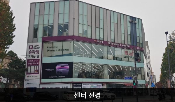 송파서비스센터의 다각형 건물 4층 붉은 간판에 'LG전자 BEST SHOP & 서비스센터'라고 적혀 있습니다. 건물 전체에 유리창이 크고 많습니다.