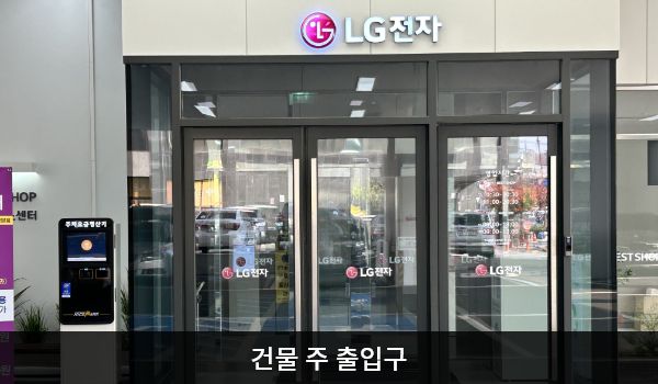 천안서비스센터의 1층 주차장을 통해 들어갈 수 있는 여닫이문 출입구가 있습니다. 문 위에 'LG전자'라고 쓰여 있습니다.