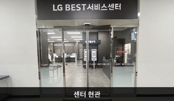 천안서비스센터의 4층 서비스센터 위쪽 큰 검은색 간판에 'LG BEST 서비스센터'라고 적혀 있습니다. 현관문은 자동문입니다. 들어오시면 앞에 셀프 접수기, 오른쪽에 부품 판매 창구가 있습니다.