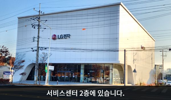 구미서비스센터의 서비스센터 건물은 흰색이며 창문이 거의 없고, 1층에만 긴 유리창이 있습니다. 건물에 'LG전자'라고 쓰여 있습니다.