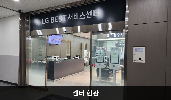 구미서비스센터의 2층 서비스센터 위쪽 큰 회색 간판에 'LG BEST 서비스센터'라고 적혀 있습니다. 현관문은 자동문입니다. 들어오시면 정면에 셀프 접수기, 왼쪽에 접수 창구가 있습니다.