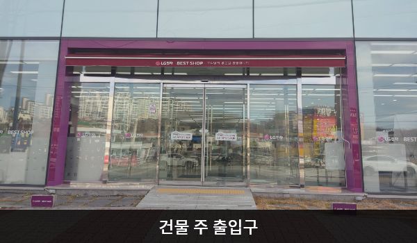 원주서비스센터의 대로 앞, 건물 중앙에 여닫이문 출입구가 있습니다. 문 앞에 약간의 경사가 있어 도로와 높이 차이가 있으며, 문 앞에 점자블록이 있습니다. 여닫이문을 열고 들어간 후, 문이 한 번 더 있습니다.
