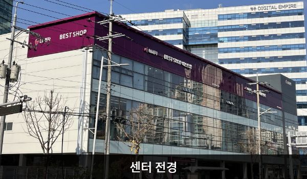 안양서비스센터의 건물 3층 붉은 간판에 'LG전자 BEST SHOP 베스트샵', 'LG전자 BEST 서비스센터'라고 적혀 있습니다. 1층은 주차장으로 되어 있으며, 건물 정면에 유리창이 크고 많습니다.