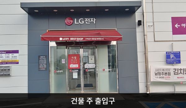 남청주서비스센터의 건물 주 출입구 위에는 검은 바탕에 'LG전자' 문구가 적혀 있습니다. 그 아래 붉은 차양막이 있으며, 출입문은 자동문입니다.