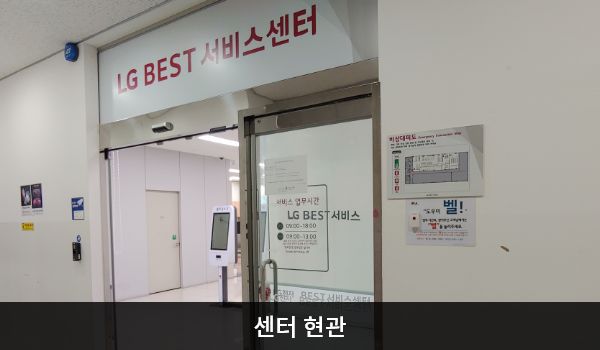 남청주서비스센터의 센터 현관 위쪽에 'LG BEST 서비스센터'라는 문구가 적혀 있으며, 그 아래에 자동문이 있습니다. 문을 열고 들어가면 앞에 셀프 접수기가 있습니다.