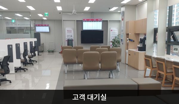남청주서비스센터의 현관문을 열고 들어오시면 좌측에 대기 의자가 마련되어 있습니다. 대기 공간 왼쪽 벽면에 셀프바와 정수기가 있고, 오른쪽에는 상담 창구가 있습니다.