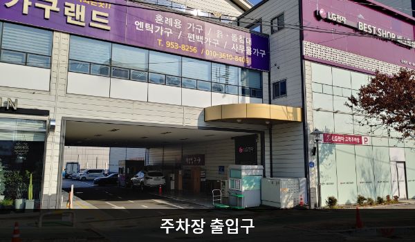 광산서비스센터의 건물 왼쪽에 주차장 출입구가 있습니다. 출입구 오른쪽, 건물 외벽에 'LG전자 고객주차장', 'P'라는 문구가 적혀 있습니다.
