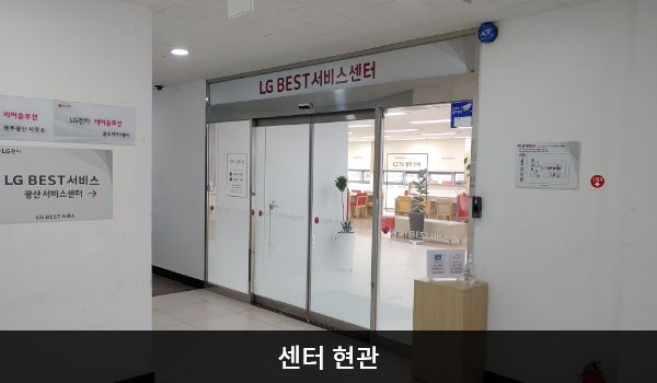 광산서비스센터의 센터 현관 위쪽에 'LG BEST 서비스센터'라는 문구가 적혀 있으며, 그 아래에 유리로 된 자동문이 있습니다.