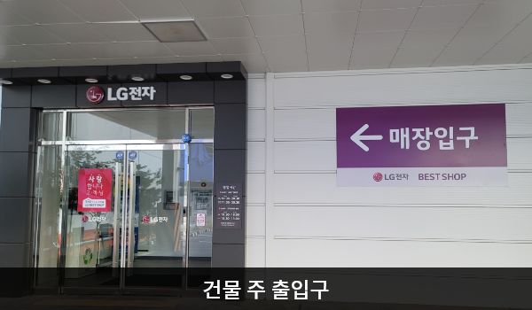 남동서비스센터의 건물 주 출입구 오른쪽 벽면에는 '매장입구', 위에는 검은 바탕에 'LG전자' 문구가 적혀 있습니다. 양쪽 유리문 안쪽에 긴 손잡이가 있습니다.