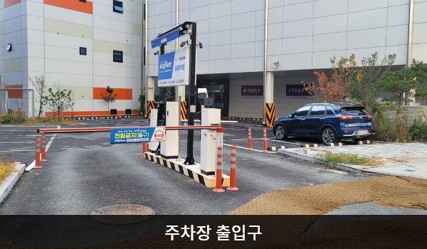 남동서비스센터의 건물 뒤쪽에 주차장이 있습니다. 건물 오른쪽과 그 옆 건물 사이에 주차장으로 들어가는 출입구가 있습니다.