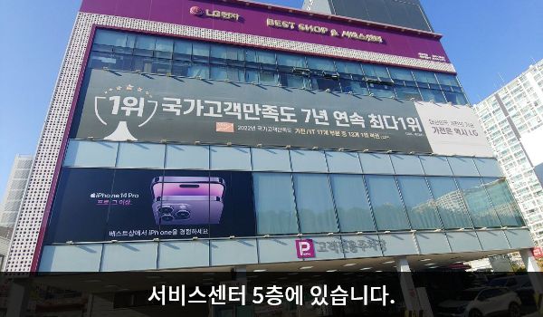 해운대서비스센터의 서비스센터 건물 1층은 주차장입니다. 건물 꼭대기 간판에 흰색 글씨, 분홍색 바탕으로 'LG전자 BEST SHOP & 서비스센터'라고 쓰여 있습니다.