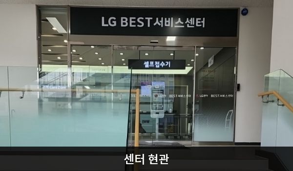 진주서비스센터의 2층 서비스센터 위쪽 큰 검은색 간판에 'LG BEST 서비스센터'라고 적혀 있습니다. 현관문은 자동문입니다. 들어오시면 정면에 셀프 접수기와 접수 창구가 있습니다.