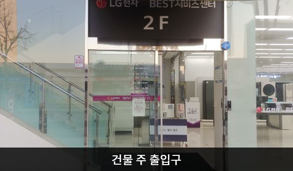 정읍서비스센터의 건물 주 출입구 위에는 'LG전자 BEST 서비스센터 2F'라고 적혀 있습니다. 자동문으로 되어 있으며, 문 오른쪽에 문 열림 버튼이 있습니다.