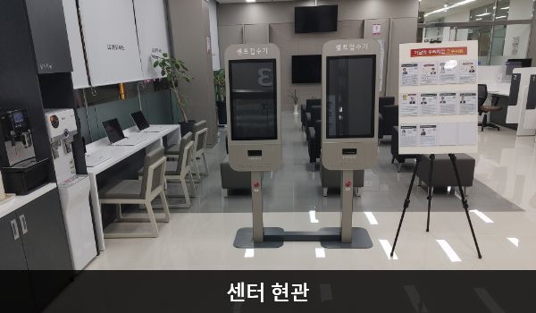파주서비스센터의 센터 현관문을 열고 들어오시면 앞쪽에 셀프 접수기가 있으며, 왼쪽에 셀프바와 정수기가 있습니다.