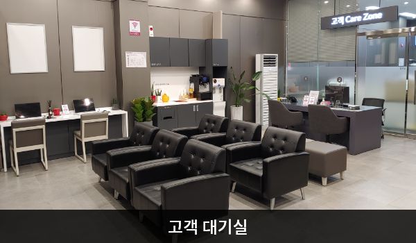 서안산서비스센터의 현관문으로 들어오시면 왼쪽에 상담 창구와 고객 대기실이 있습니다. 앉아서 대기하실 수 있는 의자가 마련되어 있습니다. 정수기와 커피, 대기 중 이용하실 수 있는 PC도 준비되어 있습니다.