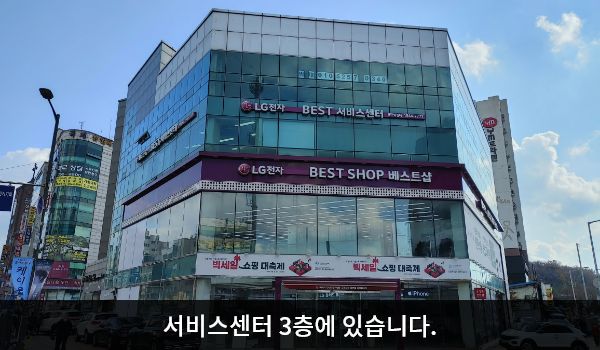 성남서비스센터의 다각형의 건물 3층에 'LG전자 BEST 서비스센터'라고 적힌 간판이 있습니다. 그 아래층 붉은 간판에는 'LG전자 BEST SHOP 베스트샵'이라고 적혀 있습니다.