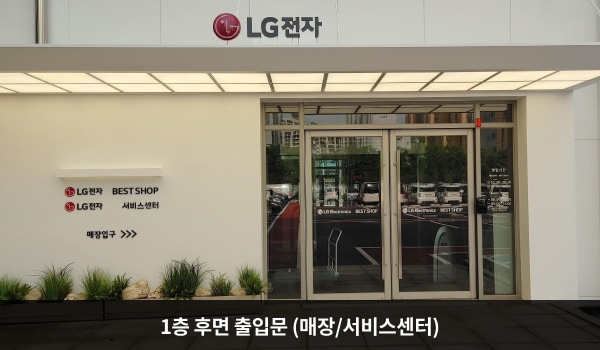 북대구서비스센터의 건물 출입구는 정면 주 출입구와 우측 출입문 두 군데가 있습니다. 1층 후면 출입문 위에는 'LG전자', 왼쪽 벽에는 'LG전자 BEST SHOP', 'LG전자 서비스센터', '매장입구'라고 적혀 있습니다. 양 유리문 안쪽에 긴 손잡이가 있습니다.