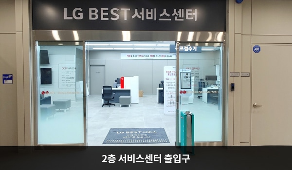 북대구서비스센터의 센터 현관 위쪽에 'LG BEST 서비스센터'라는 문구가 적혀 있습니다. 그 아래에 유리로 된 자동문이 있으며, 문을 열고 안으로 들어가면 오른쪽에 셀프 접수기가 있습니다.