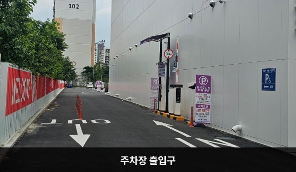 북대구서비스센터의 건물 왼쪽에 주차장 출입구가 있습니다. 출입구 왼쪽 벽에는 붉은 바탕에 흰 글씨로 'WELCOME'이라고 쓰여 있습니다. 차량 제한 높이는 3.3m입니다.
