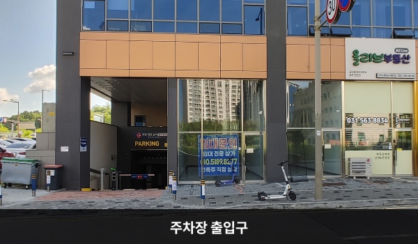 구리서비스센터의 건물 지하에 주차장이 있습니다. 주차장 출입구 위쪽에는 'PARKING'이라는 문구가 적혀 있습니다.