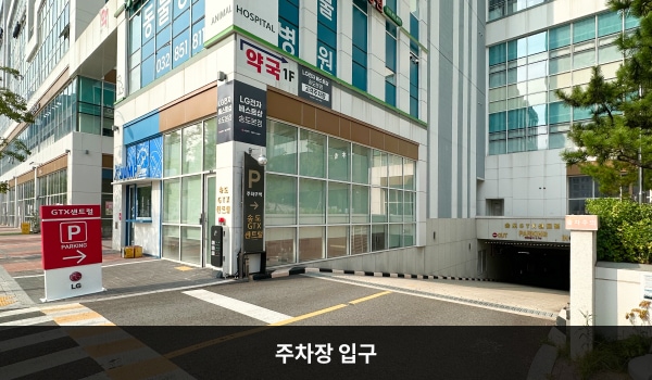 연수서비스센터의 건물 지하에 주차장이 있습니다. 주차장 출입구 왼쪽 붉은색 입간판에는 위에서부터 아래로 'GTX센트럴', 'P', LG'라는 글자가 크게 적혀 있습니다.