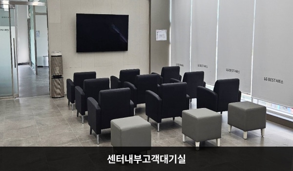연수서비스센터의 현관문으로 들어오시면 대기하실 수 있는 의자가 마련되어 있습니다. 의자 앞쪽 벽에는 커다란 TV가 걸려 있습니다.