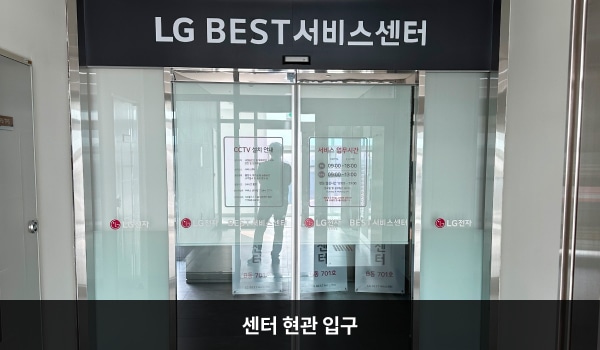 연수서비스센터의 센터 현관 위쪽에는 검은 바탕에 'LG BEST 서비스센터'라는 문구가 적혀 있으며, 그 아래에 유리로 된 자동문이 있습니다.
