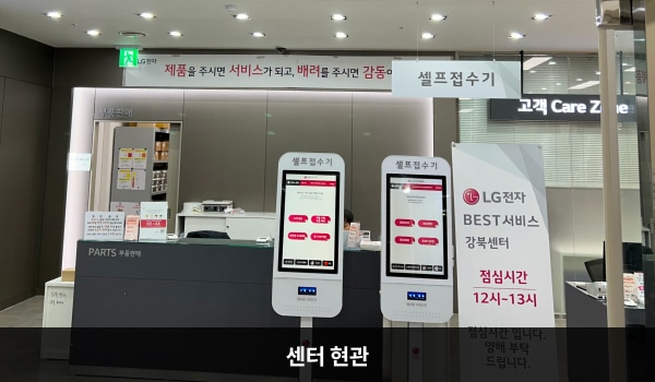 강북서비스센터의 4층 서비스센터 위쪽 큰 검은색 간판에 'LG BEST 서비스센터'라고 적혀 있습니다. 현관문은 자동문입니다. 들어오시면 앞에 셀프 접수기가 2대 있고, 부품 판매 창구가 있습니다.