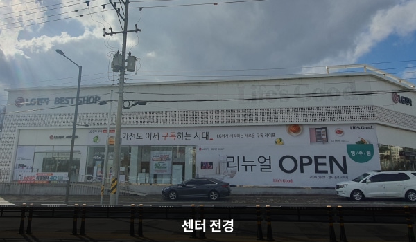 영주서비스센터의 서비스센터 건물은 가로로 길고 1층에 베스트샵과 서비스센터가 함께 있습니다. 건물 꼭대기 간판에 흰색 바탕으로 'LG전자 BEST SHOP Life's Good' 문구가 쓰여 있습니다.