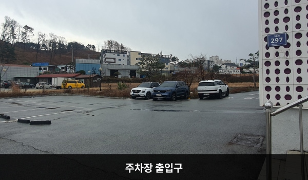 영주서비스센터의 건물 왼쪽에 지상 주차장 출입구가 있습니다. 'Parking'이라고 쓰인 곳입니다. 매장 출입구는 대로 앞에 있는 주 출입문입니다.