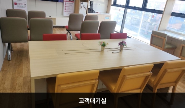 논산서비스센터의 고객대기실에는 앉아서 대기하실 수 있는 의자가 곳곳에 마련되어 있습니다. TV 오른쪽에 셀프바와 정수기가 있습니다.