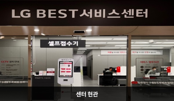 동대전서비스센터의 센터 현관 위쪽에 'LG BEST 서비스센터'라는 문구가 적혀 있으며, 그 아래에 유리로 된 자동문이 있습니다. 문을 열고 들어가면 정면에 부품 판매 데스크와 셀프 접수기가 있습니다.