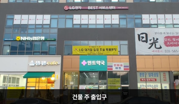 구리서비스센터의 외부 간판에는 'LG전자 BEST 서비스센터 구리센터 1544-7777'이라고 쓰여 있습니다. 그 아래층에는 '민트약국'이라는 간판이 걸려 있습니다. 민트약국 왼쪽에 주 출입구가 있습니다.