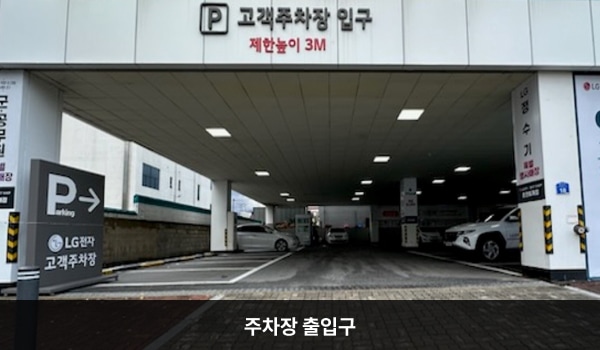 춘천서비스센터의 건물 1층 왼쪽에 지상 주차장 출입구가 있습니다. 'P 고객주차장 입구 제한 높이 3M'라고 쓰인 곳입니다.