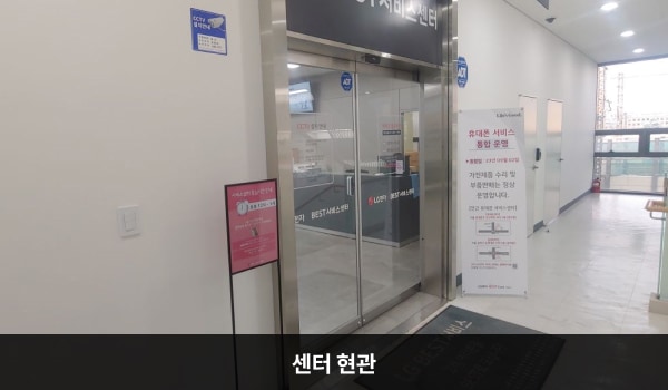광진서비스센터의 4층 현관문 위쪽 큰 회색 간판에 'LG BEST 서비스센터'라고 적혀 있습니다. 현관문은 자동문이고 문 왼쪽에 열림 버튼이 있습니다. 들어오시면 앞에 셀프 접수기가 있습니다.