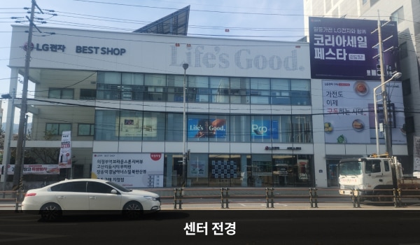 의정부서비스센터의 건물 3층 흰색 간판에 'LG전자 BEST SHOP'이라고 적혀 있습니다. 건물 전체에 유리창이 크고 많습니다.