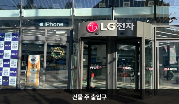강서서비스센터의 건물 주 출입구는 두 군데가 있습니다. 대로변 쪽 출입문은 회전문이고, 건물 안쪽 출입문은 유리로 된 여닫이문입니다. 안쪽 출입문 오른쪽 벽면에는 '매장입구'라고 적혀 있습니다.