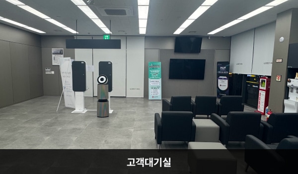 강동서비스센터의 현관문을 열고 안쪽으로 들어오시면 좌측에 앉아서 대기하실 수 있는 의자가 마련되어 있습니다. 대기 공간 옆 창가 쪽에는 셀프바와 정수기가 있습니다.
