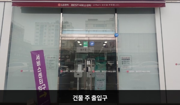 북인천서비스센터의 건물 주 출입구 위에는 'LG전자 BEST 서비스센터'라는 문구가 적혀 있습니다. 양쪽 유리문 안쪽에 긴 손잡이가 있으며, 문을 열고 들어가면 앞에 셀프 접수기가 있습니다.